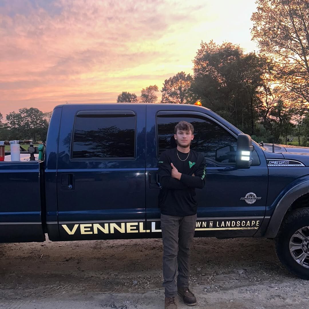 Ryan Vennell with his black work truck under a peach sunset sky in Winslow Township